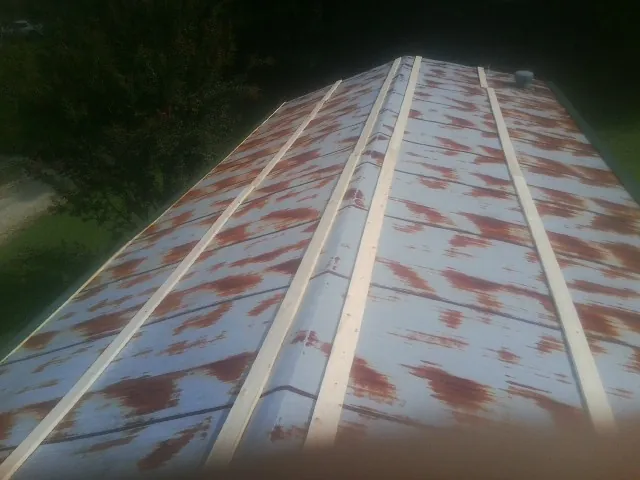 Rusted metal roof panels with new wood purlins before replacement — Storm Damage Roof Repair in Limon by Roofing Brothers