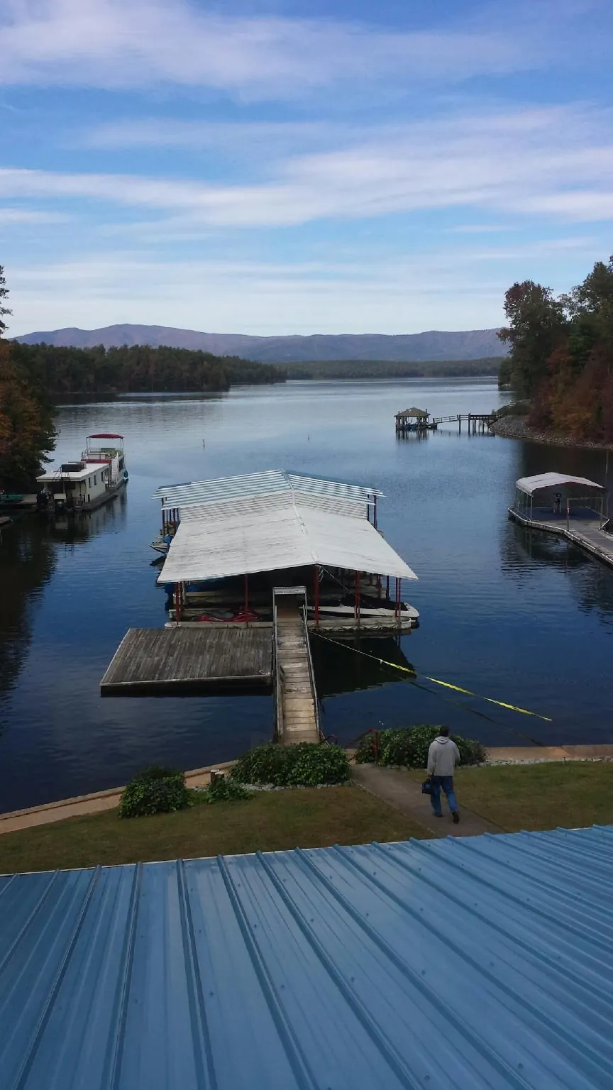 View across a lake from a newly installed blue metal roof in Limon