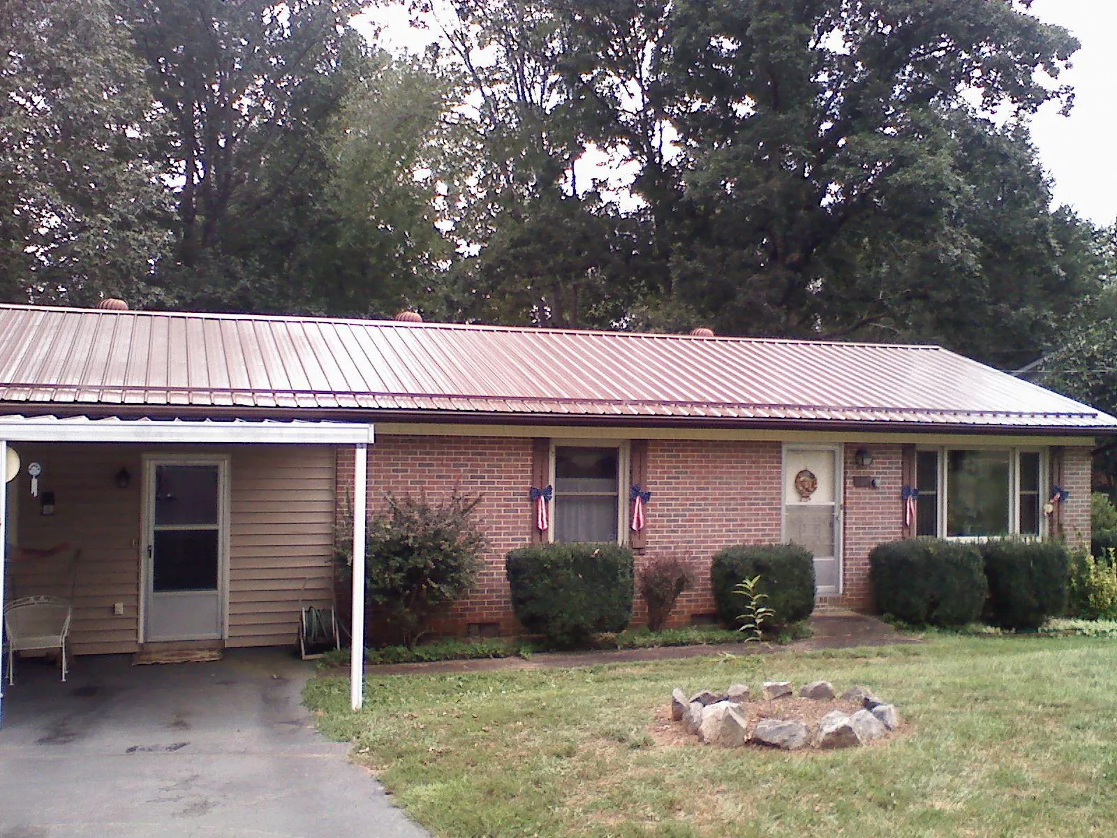 Bronze metal roof and carport on a brick ranch home — Roof Repair work by our crew in Limon